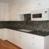 White cabinets with oven hood and angled upper cabinet at window